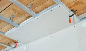 Structure métallique pour un double plafond en cours d'installation, avec des plaques de plâtre fixées.
