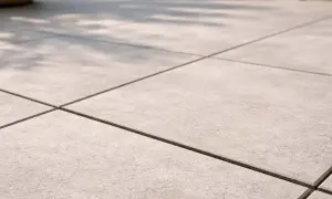 Pavimentazione esterna con piastrelle grigie e fughe scure, perfette per un terrazzo moderno. Il cemento per fughe esterne garantisce durata e stile.