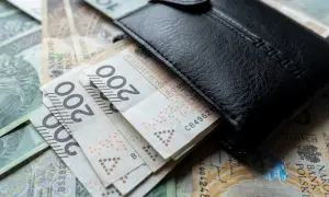 Czarny portfel na stosie polskich banknotów 200 zł. Czy to wystarczy na minimalne wynagrodzenie?