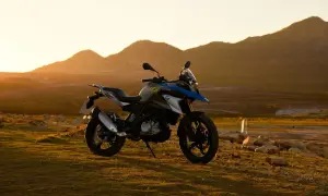 Motocykl BMW GS 310 na tle gór o zachodzie słońca.