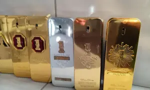 Kolekcja perfum "1 Million" Paco Rabanne, w tym wersje 100ml, błyszczące złote i srebrne flakony w kształcie sztabek.