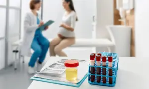 Badanie moczu w ciąży: obecność leukocytów może wskazywać na infekcję. Na stole próbka moczu, krew i USG.
