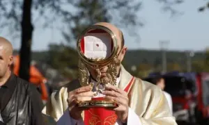 Kapłan trzyma monstrancję z hostią, przypominającą cud eucharystyczny w Sokółce.