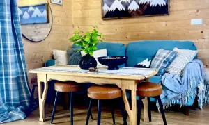 Przytulny salon z kanapą, stołem i taboretami. Idealne miejsce, które sugeruje, który rodzaj zakwaterowania oferuje najlepsze udogodnienia dla narciarzy.
