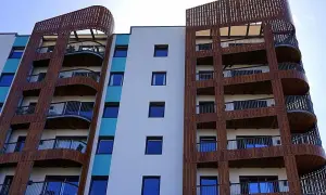Moderne Wohnanlage mit vielen Balkonen, die von Holzlamellen umrahmt sind. 250 Baugb.