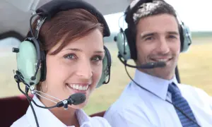Para, czy pilot może mieć wadę wzroku? Dwoje ludzi w słuchawkach z mikrofonem w samolocie.