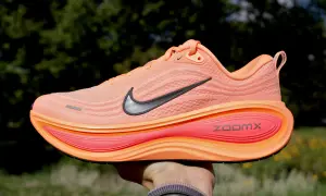 Pomarańczowy but sportowy z czarnym logo Nike i napisem ZoomX. Jedna z wielu marek butów, które oferują komfort i styl.