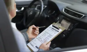 Osoba w samochodzie wypełnia dokumenty dotyczące akcyzy za auto.