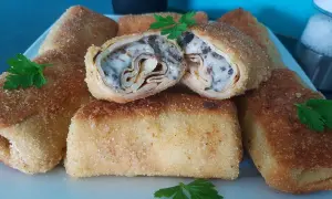 Chrupiące krokiety z pieczarkami i serem, jeden przekrojony, ukazujący bogate wnętrze.