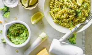 Frische Pasta mit cremigem Brokkoli Pesto, Pinienkernen und Zitrone. Zutaten für das Pesto sind sichtbar.