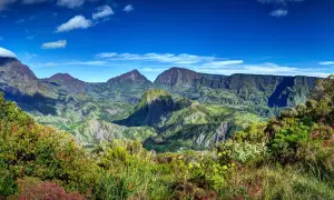 Paysage montagneux verdoyant sous un ciel bleu. Idéal pour réfléchir à que faire à la Réunion.