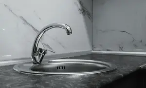 Nowa budowa baterii zlewozmywakowej stojącej. Bateria z chromowanym wykończeniem i okrągłym odpływem w zlewie.