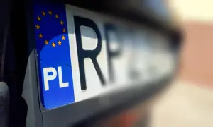 Zbliżenie na polską tablicę rejestracyjną z symbolem Unii Europejskiej. Litery "PL" i fragment numeru wskazują na rkl rejestracja.