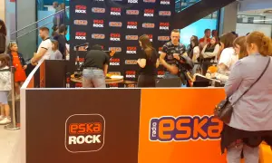 Stoisko radiowe Eska Rock z ludźmi i logo stacji.