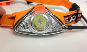 Orange Stirnlampe mit hellem LED-Licht, ein unverzichtbares Gadget für Nachtwanderungen.