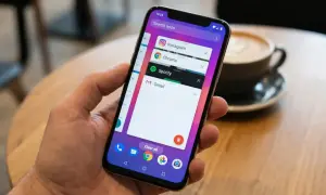 Mano sujetando un teléfono que muestra la pantalla de aplicaciones recientes, con Instagram, Chrome, Spotify y Gmail abiertas. Gestionando aplicaciones en segundo plano.
