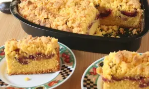 Pyszne ciasto z mąki kukurydzianej z soczystymi śliwkami i kruszonką. Dwa kawałki na talerzykach, reszta w formie.