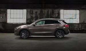 Brązowy Infiniti QX50 w profilu, zaparkowany w opuszczonym magazynie z graffiti na ścianach i dużymi oknami.