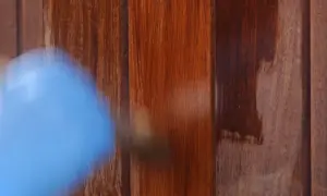 Aplicando barniz a madera impermeable para protegerla.