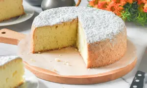 Un delicioso pa de pessic, esponjoso y cubierto de azúcar glas, listo para ser disfrutado.