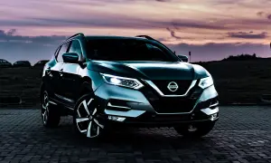Mörkgrå Nissan Qashqai parkerad vid solnedgången. Kanske ett problem med bilen som gör att den står stilla?