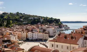Piran: malerische Altstadt mit roten Dächern, Hafen und grünen Hügeln. Entdecken Sie Piran Geheimtipps für Ihren Urlaub.