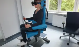 Kobieta w goglach VR na specjalnym fotelu wykonuje badanie vng. Gdzie zrobić takie badanie?