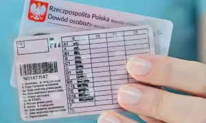 Dłoń trzyma polskie prawo jazdy z widocznymi kategoriami pojazdów, od motocykli po autobusy.