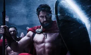 Gerard Butler jako Leonidas w filmach "300". Spartanin w deszczu, z tarczą i włócznią, gotowy do walki.