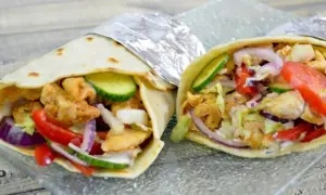 Dwie tortille z kurczakiem na zimno, pełne świeżych warzyw: pomidora, ogórka, cebuli i sałaty. Idealne na szybki lunch.