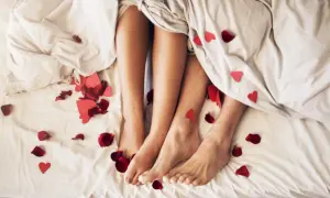 Nogi pary pod kołdrą, wśród płatków róż i serduszek. Czy to początek romansu, czy może sex z przypadku?