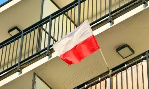 Polska flaga powiewa na balkonie. Biało-czerwone barwy symbolizują dumę i historię narodu.
