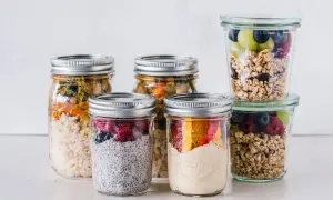 Sześć słoików z jedzeniem: owsianka, ryż z warzywami, jogurt z owocami i granola.