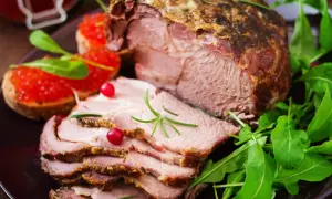 Pyszny, pieczony schab pokrojony w plastry, podany z kawiorową bruschettą i rukolą. Idealny na obiad, by dowiedzieć się, ile dusić schab do miękkości.