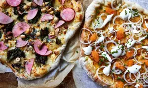 Två läckra pizzor, en med äpple och nötter, den andra en vit pizza med rom och gräddfil.