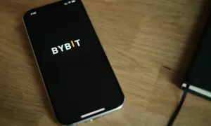 Smartfon z logo Bybit na ekranie. Zastanawiasz się nad **Bybit prowizje**? Sprawdź je na swoim urządzeniu.