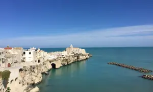 La piana della battaglia di Vieste, con le sue case bianche aggrappate alla roccia, si affaccia sul mare azzurro.