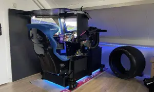 Ein beeindruckender **sim rig selber bauen**-Aufbau mit Rennsitz, Lenkrad und mehreren Bildschirmen. Daneben ein Rennreifen.