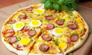 Pyszna pizza z jajkiem, kiełbasą i kukurydzą, ozdobiona zieloną cebulką i bazylią.
