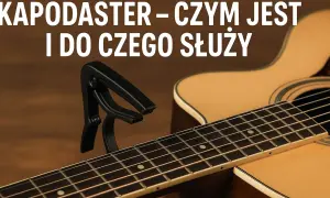 Czarny kapodaster na gryfie gitary akustycznej. Dowiedz się, jak zrobić kapodaster i do czego służy.
