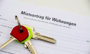 Schlüssel auf einem Mietvertrag. Der Vertrag ist für Wohnungen in Hamburg, und die Schlüssel symbolisieren den Einzug in ein neues Zuhause, vielleicht nach Prüfung des Betriebskostenspiegels Hamburg.