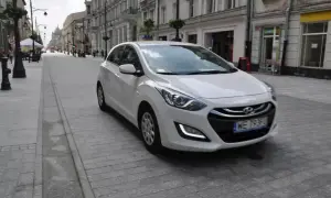 Biały Hyundai i30 1.4 benzyna na brukowanej ulicy w mieście.