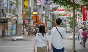 Para dowiedzieć się, jak rozmawiać z chłopakiem, obserwuj tę parę spacerującą po tętniącej życiem ulicy handlowej w Japonii, otoczonej neonami i sklepami.