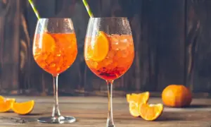 Dwa orzeźwiające Aperol Spritz z plasterkami pomarańczy i słomkami. Idealne na lato, a ich aperol spritz kcal nie są wysokie.