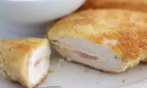 Un délicieux cordon bleu, pané et doré, révèle son cœur fondant de jambon et de fromage. Servi avec une salade verte.