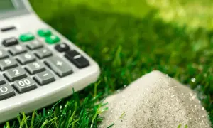 Calculadora sobre césped artificial, calculando la cantidad de arena para un proyecto de 100 m2.