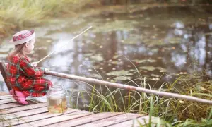 Mała wędkarza z Wielkopolski, z wędką i słoikiem na ryby, szuka idealnego miejsca gdzie na ryby z noclegiem.