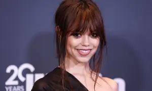 Jenna Ortega, aktorka znana z roli Wednesday Addams, uśmiecha się do obiektywu.