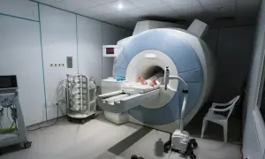 Gabinet rezonansu magnetycznego. Pacjent leży na stole aparatu MRI, przygotowany do badania. Sprawdź rezonans magnetyczny - cennik.