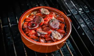 Heiß gegrillte Chorizo-Tapas in einer Tonschale, die auf einem Grillrost brutzeln.